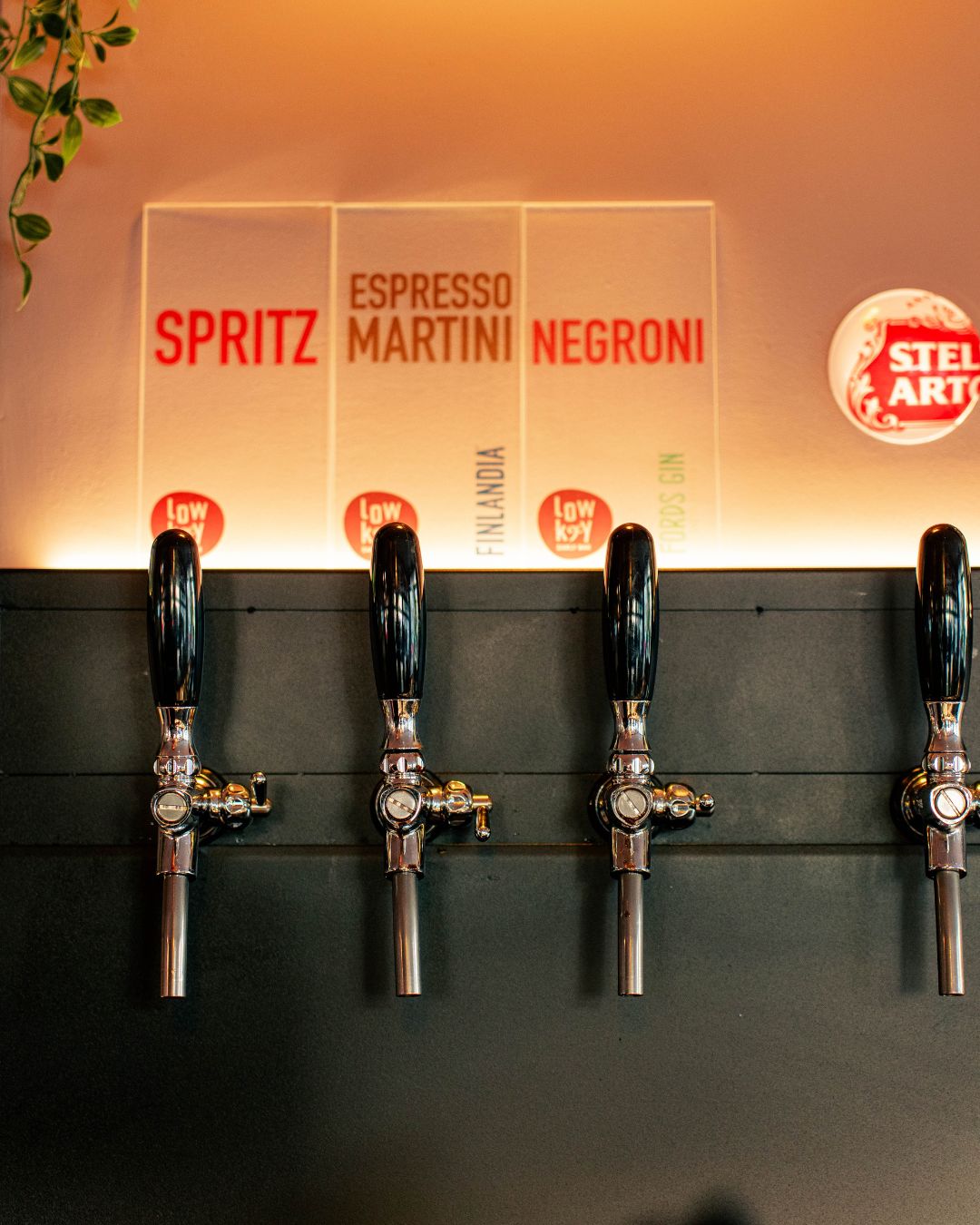 The Lowkey bar taps beneath a Spritz, Espresso Martini and Negroni sign